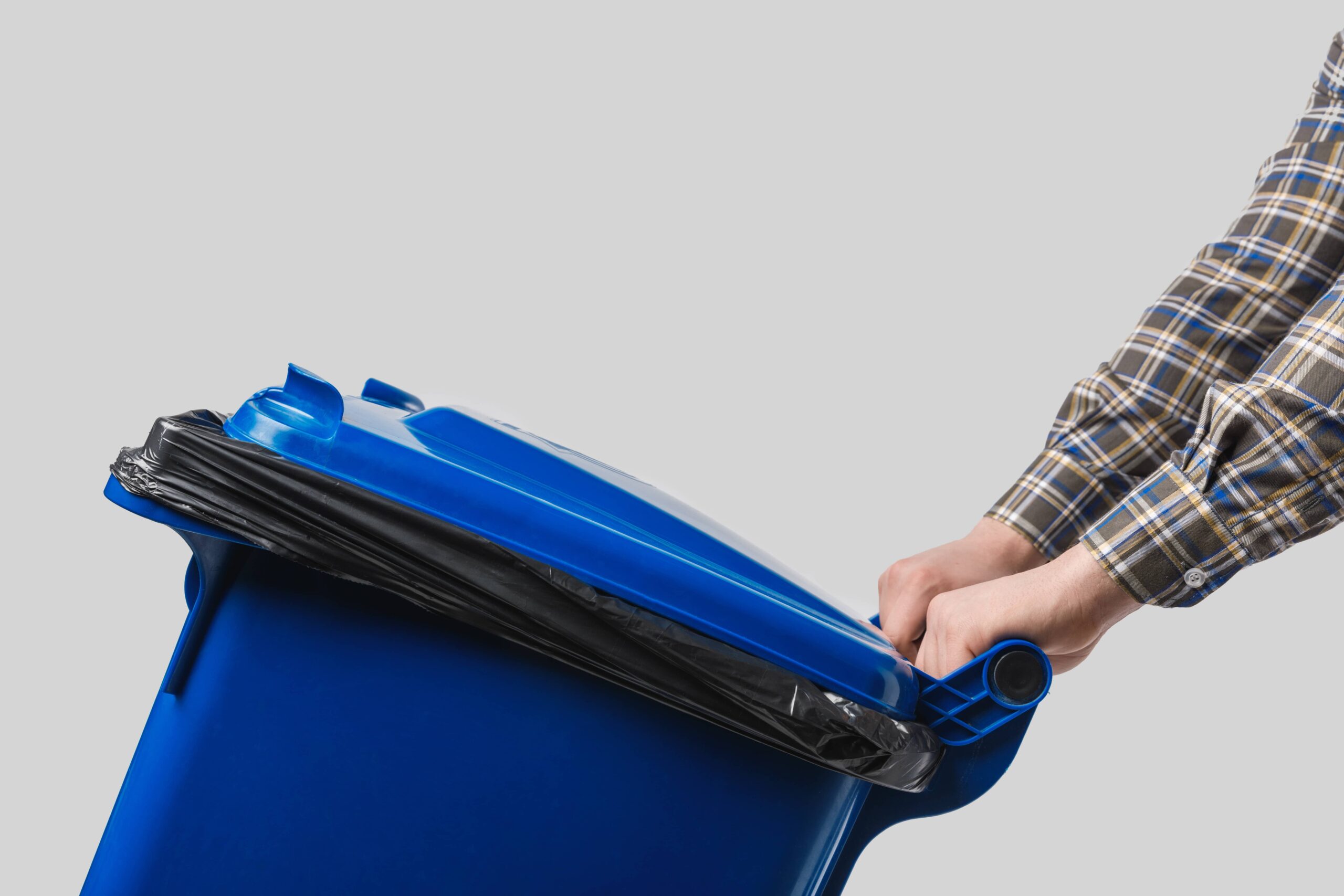 man taking out a blue trash can