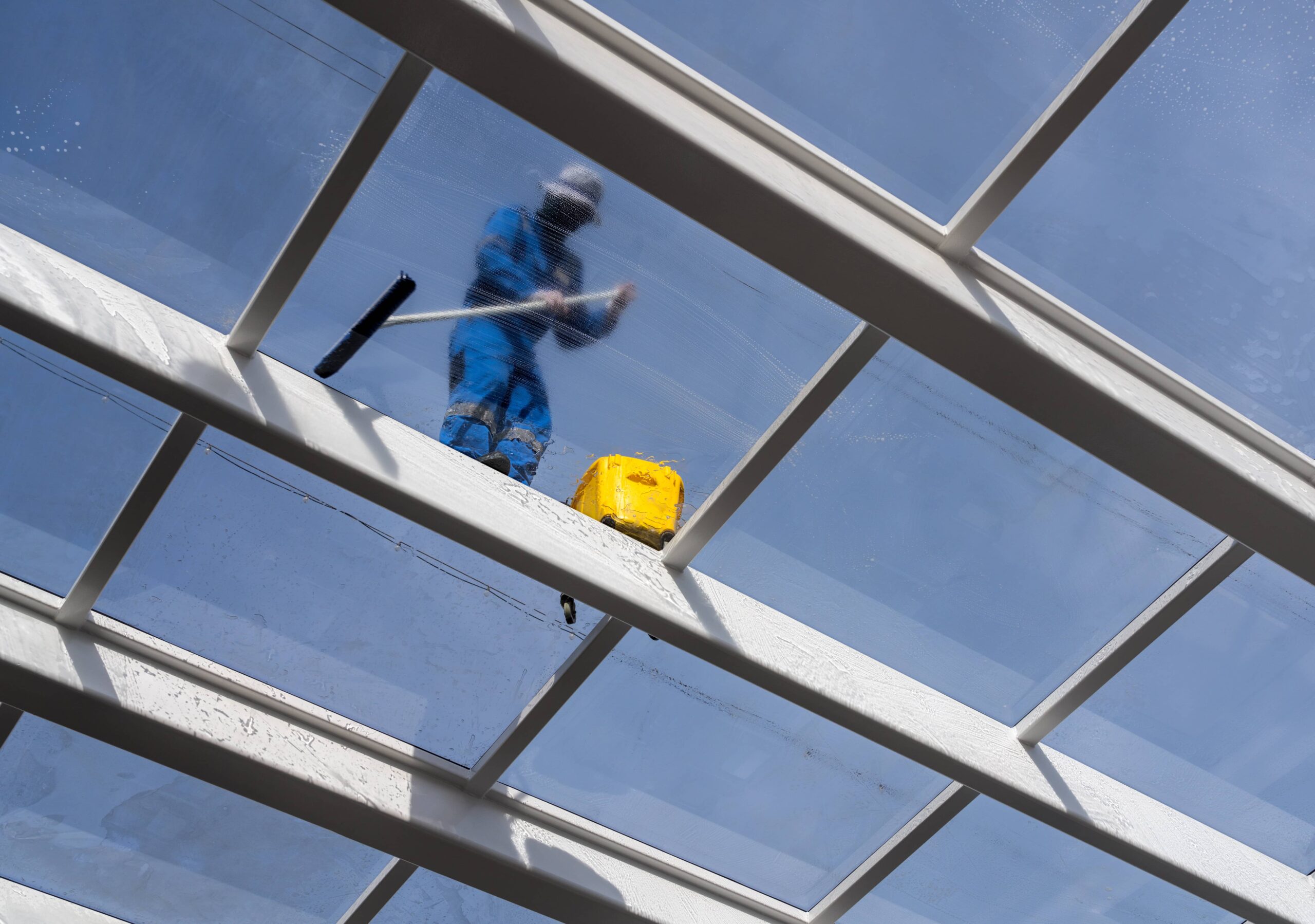 employee cleaning commercial windows