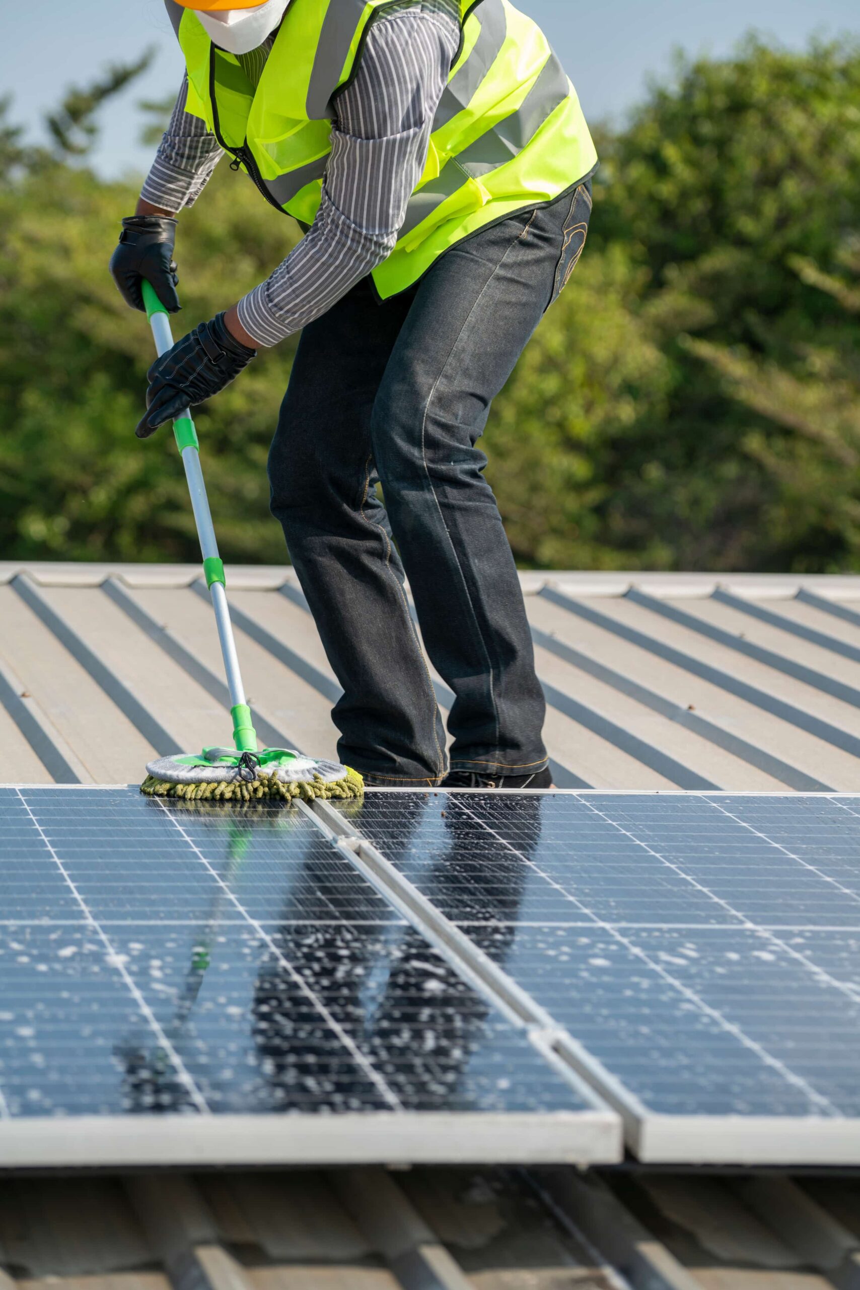 h2o cleaning solutions employee soaping down a solar panel